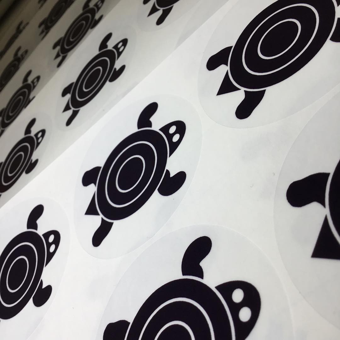 Custom clear vinyl sticker with monochromatic turtle logo – transparent branded label