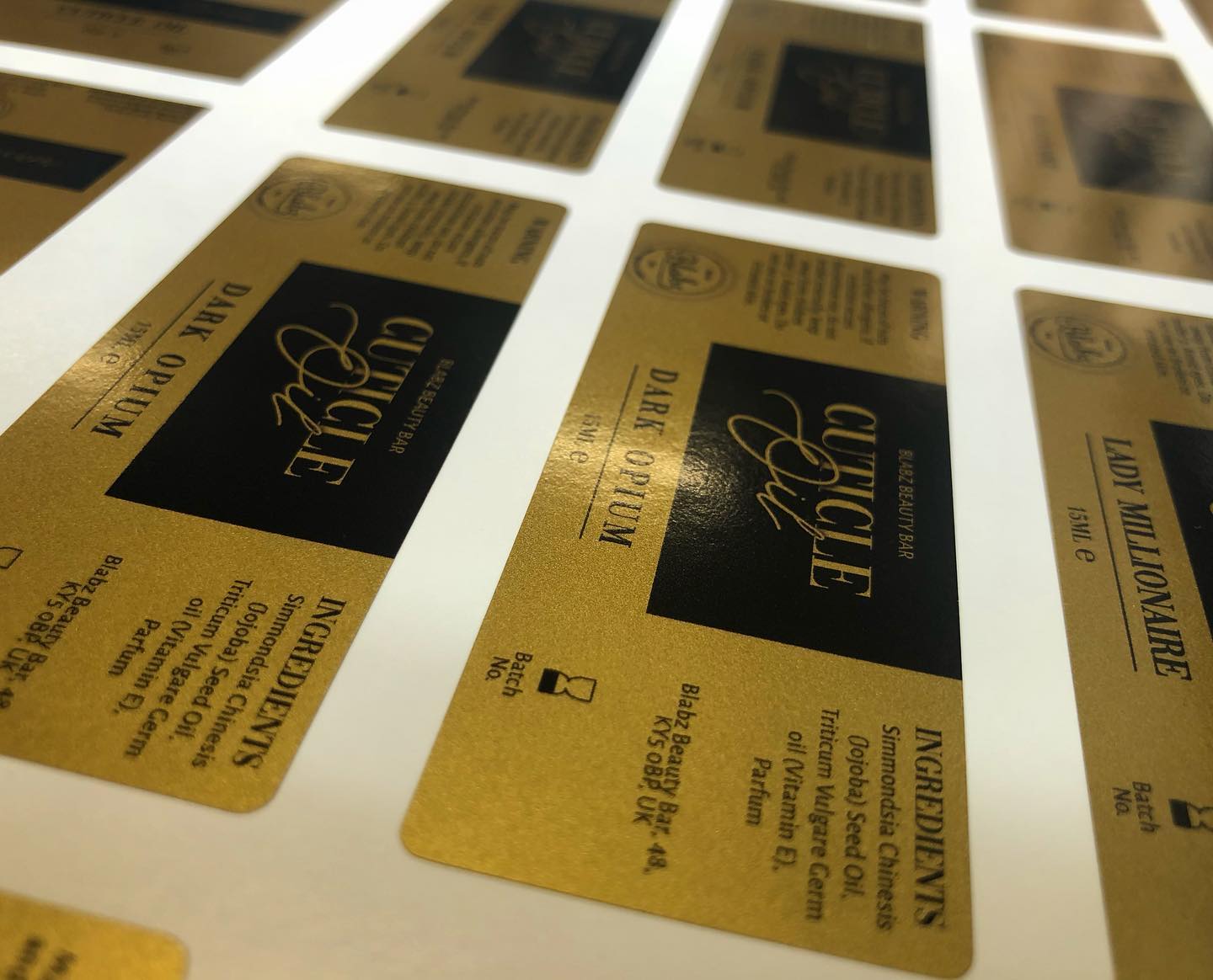 Custom rectangular satin gold vinyl cosmetic labels – black and gold branded luxury stickers
